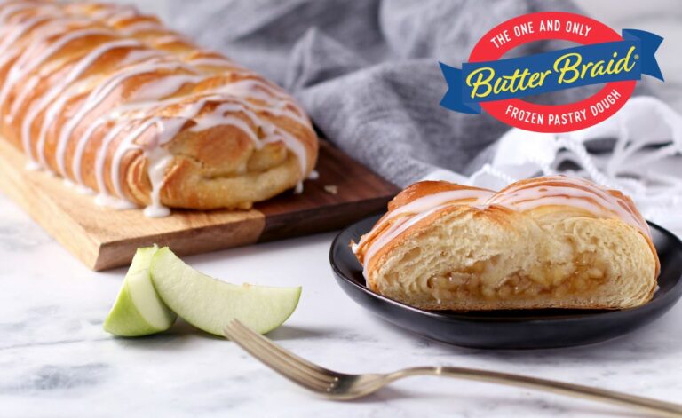 Butter Braid Pastry Fundraising Tool Kit - Apple Pastry with slice on plate. 2 green apple slices and fork next to pastry on marble table with gray dish towel in background